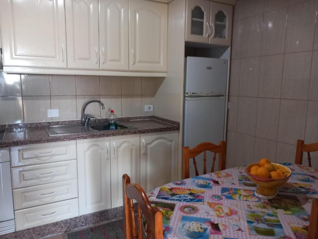 a kitchen with a table with a bowl of fruit on it at Casa rural entre la naturaleza Gomera in El Cercado