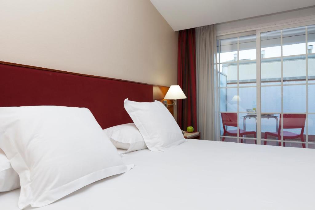 A bed or beds in a room at URH Ciutat de Mataró