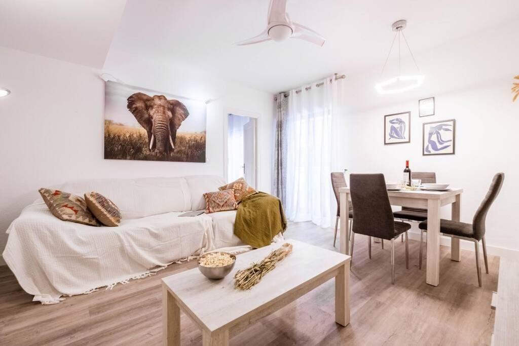 ein Wohnzimmer mit einem weißen Sofa und einem Tisch in der Unterkunft Casa Ariño Casco Antiguo Arcade para jugar in Saragossa
