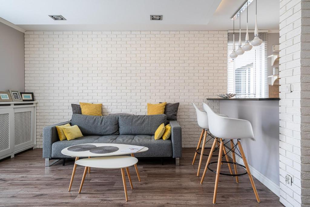 ein Wohnzimmer mit einem Sofa und einem Tisch in der Unterkunft RentPlanet - Apartament Dubois in Breslau