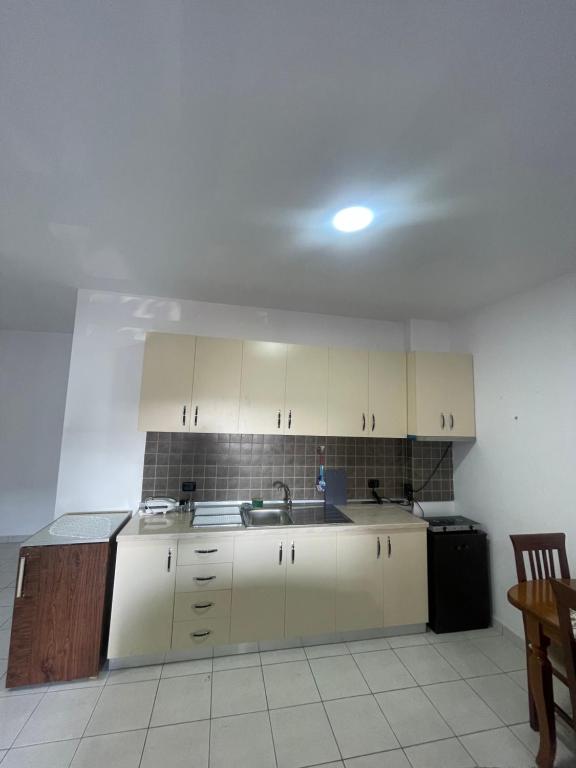 a kitchen with white cabinets and a sink at Gega Apartment in Shkodër