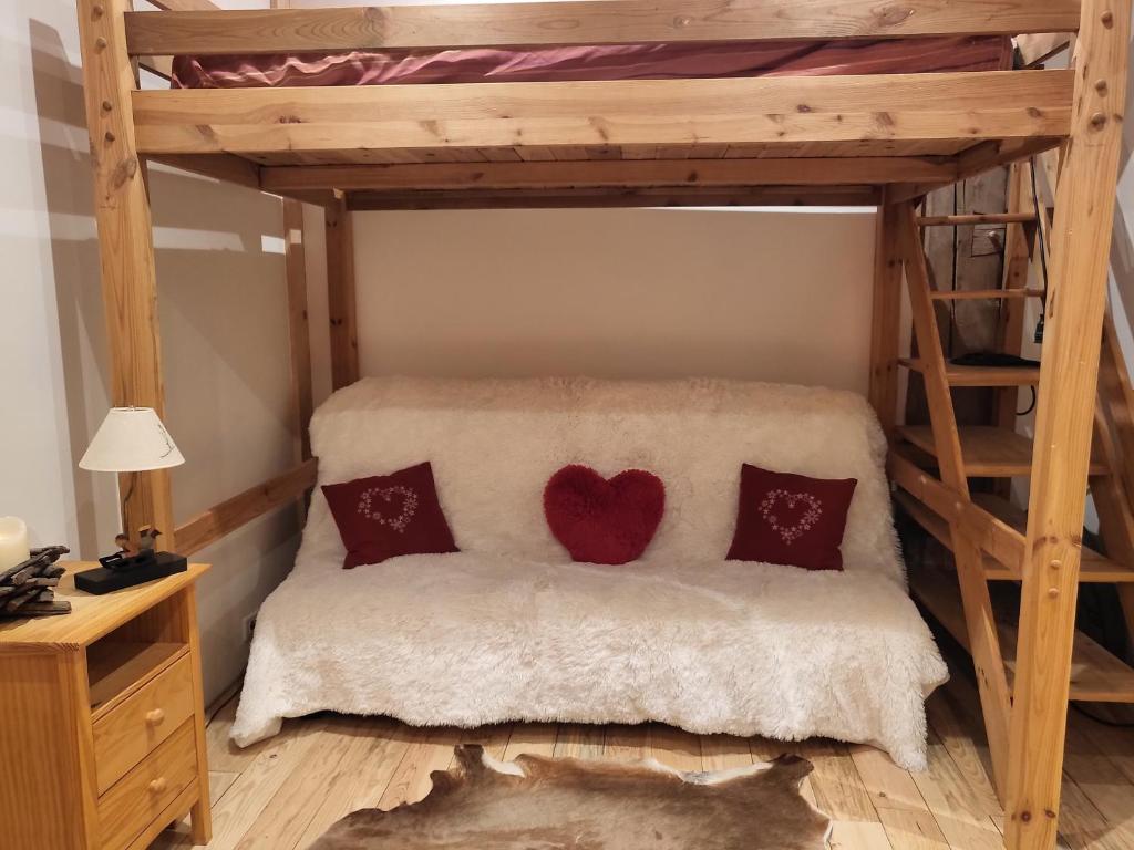 a bedroom with a loft bed with two red pillows at Le Nid des Cerfs in Essert-Romand