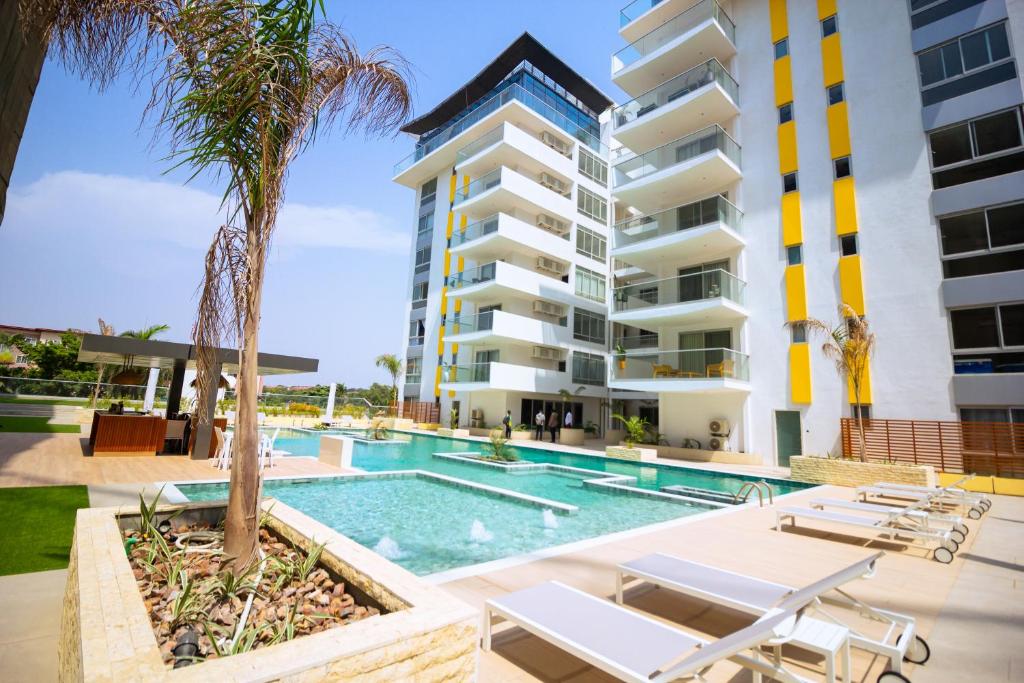 a swimming pool with chaise lounge chairs in front of a building at The Pavilion 1BDR Luxury Apt in Accra