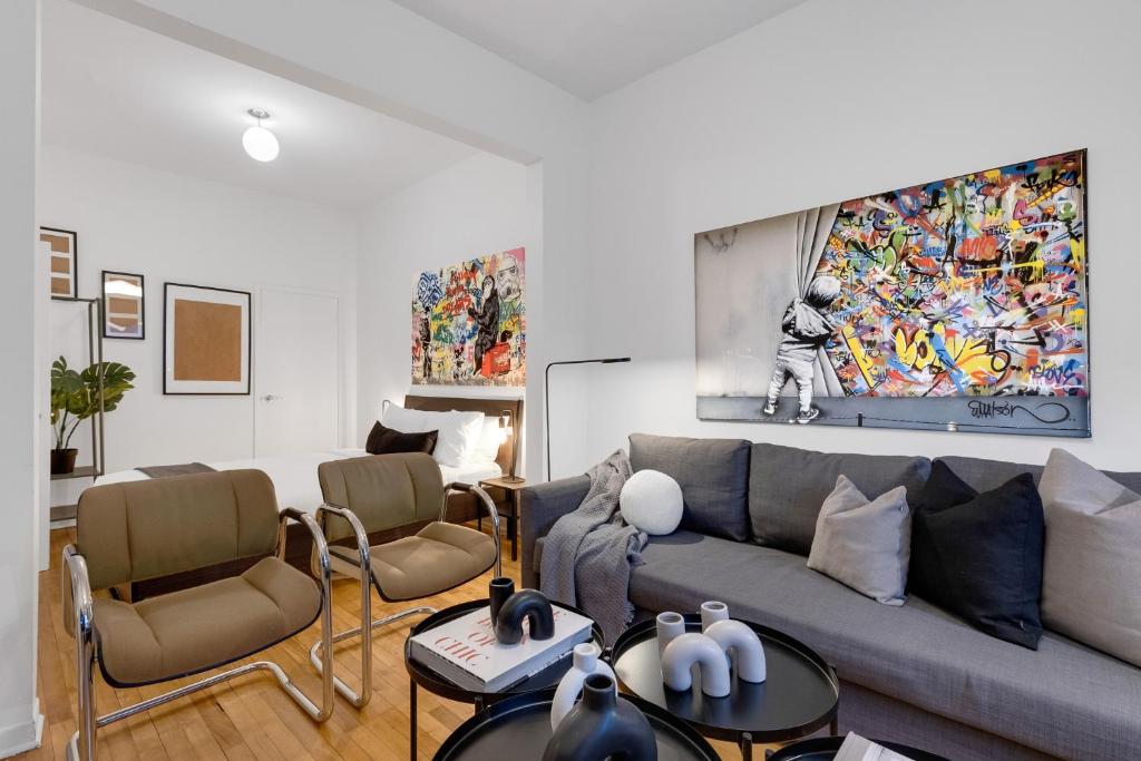 uma sala de estar com um sofá e uma pintura na parede em Liv MTL Avenue em Montreal