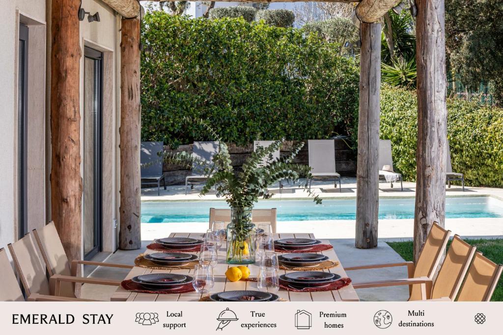 a table set for a meal on a patio with a pool at Casa Ciudamar Costa Brava - BY EMERALD STAY in Begur