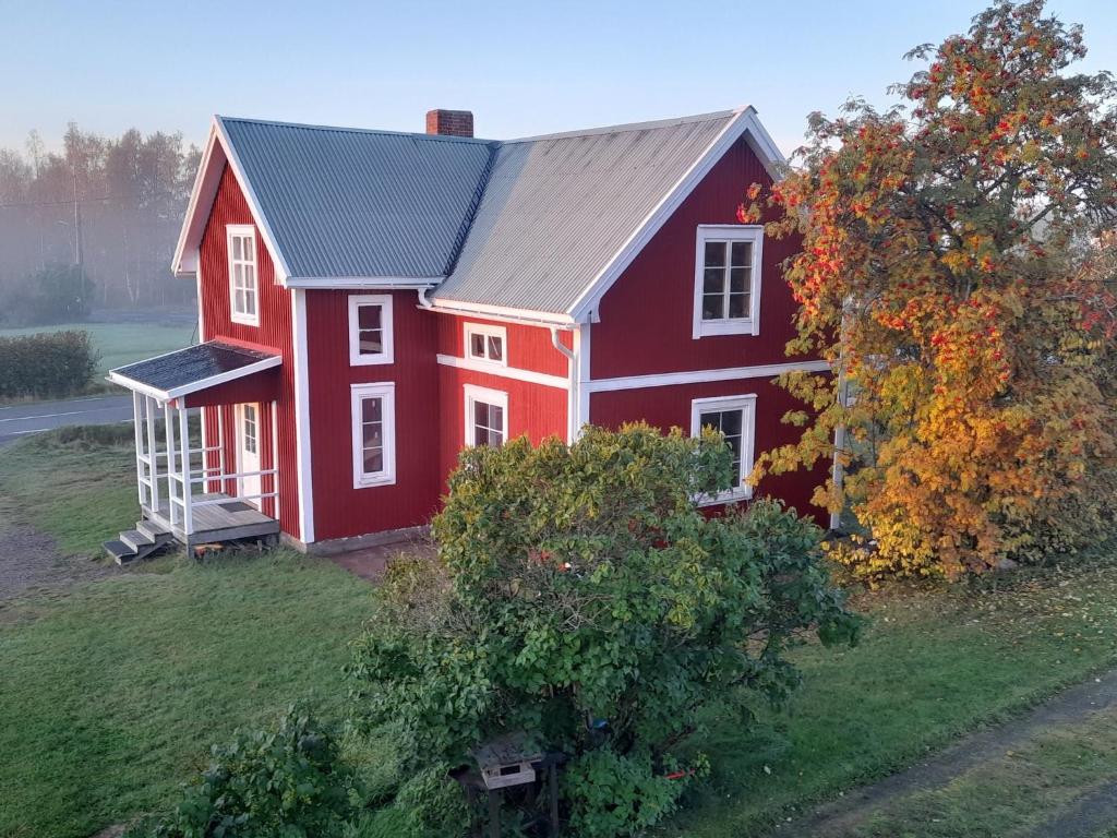 una casa roja sentada en la cima de un campo en Old timber house, en Kalix