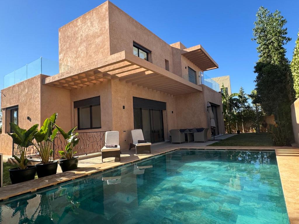 a house with a swimming pool in front of a house at Palais Ouzdi in Marrakesh