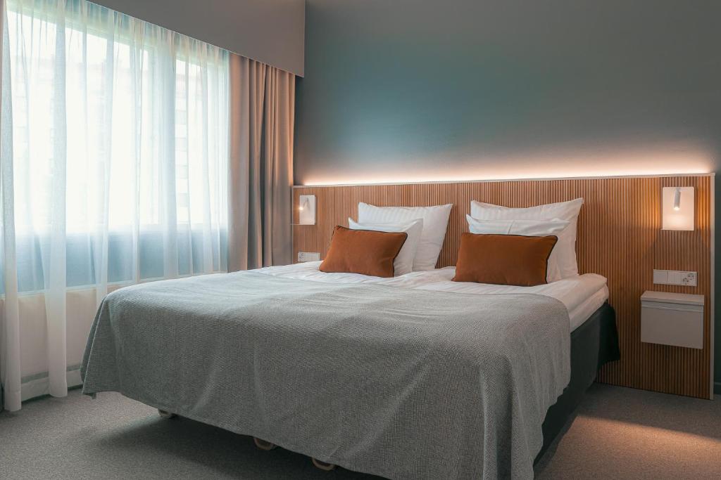 a bedroom with a large bed with two pillows at Original Sokos Hotel Seurahuone Savonlinna in Savonlinna