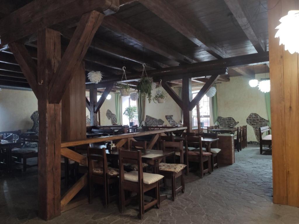 a dining room with a bar and some chairs at Хмеляр in Dubno
