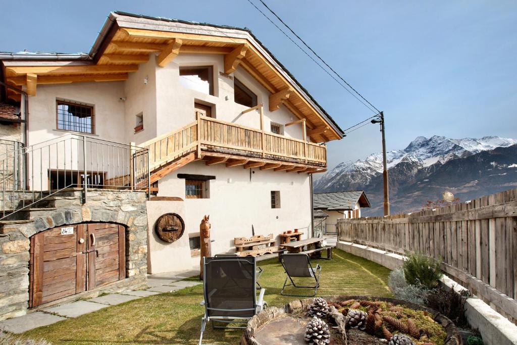 a house with a balcony and a table and chairs at Il Capriolo Aosta in Aosta