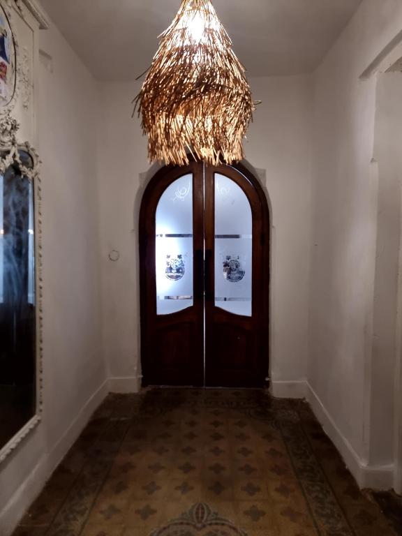 a hallway with a wooden door with a chandelier at Las catalinas hospedajes in Chilecito