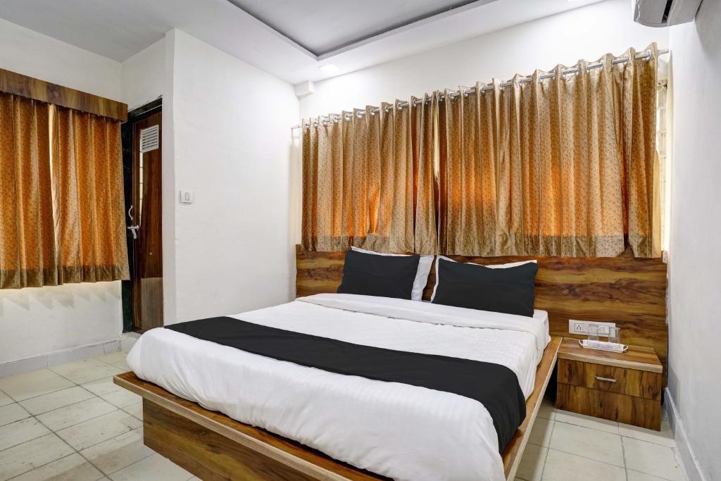 a bedroom with a large bed in front of a window at Hotel Apollo in Ahmedabad