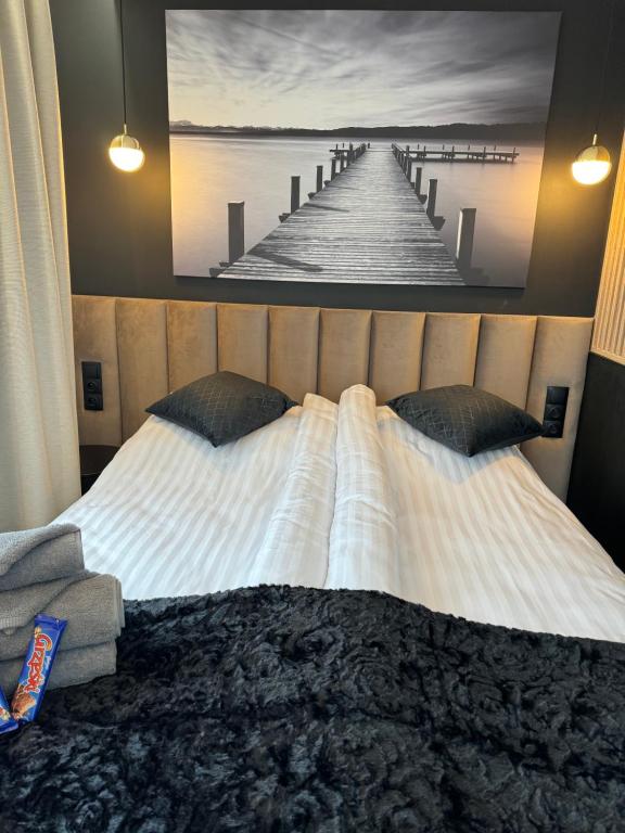 a bedroom with a bed with a picture of a pier at Apartamenty Beauty & SPA in Ełk