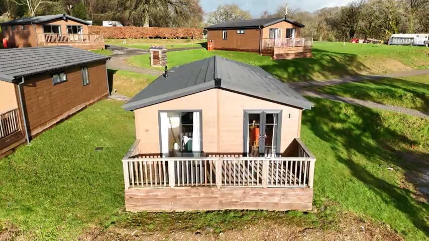 an aerial view of a small house with a porch at Two Bedroom Lodge In The Country - Owl, Peacock & Meadow in Liskeard