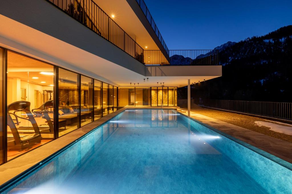 una piscina en medio de una casa en Hotel Alpenrose Dolomites en La Valle