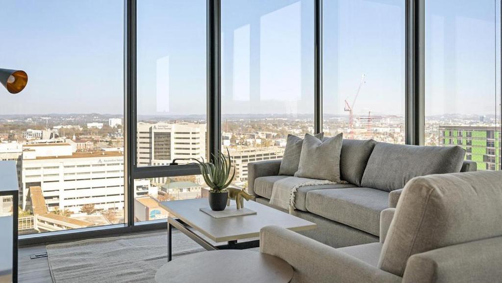 uma sala de estar com um sofá e uma mesa em Landing - Modern Apartment with Amazing Amenities (ID1401X746) em Nashville