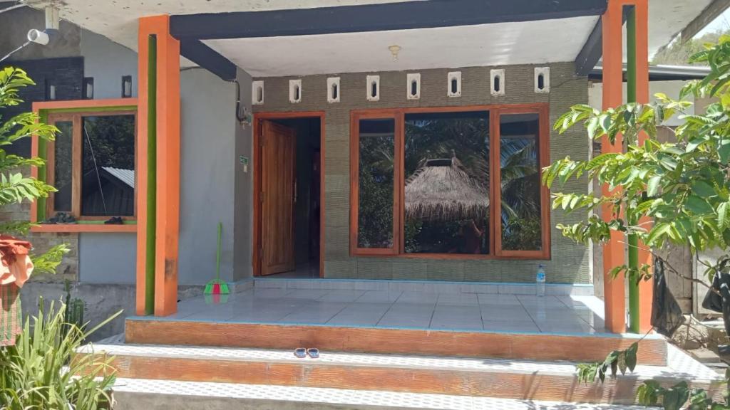 eine Veranda eines Hauses mit orangefarbenen Säulen in der Unterkunft BALE G-SHOQ in Kuta Lombok