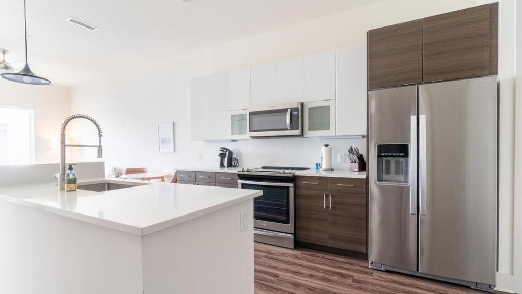 una cocina con nevera de acero inoxidable y armarios de madera en Landing Modern Apartment with Amazing Amenities (ID2441X04) en Pittsburgh