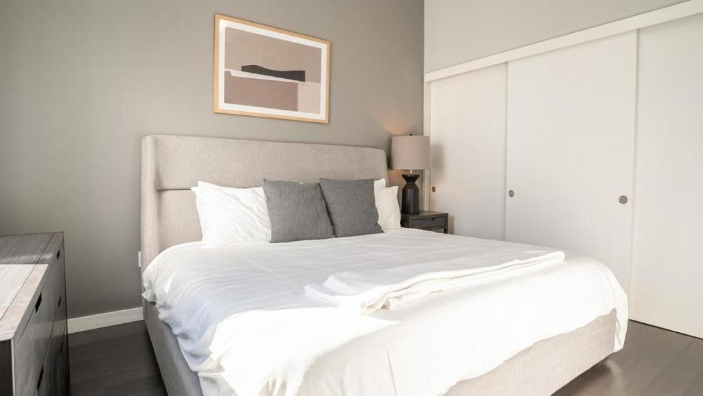 1 dormitorio con 1 cama grande con sábanas blancas en Landing Modern Apartment with Amazing Amenities (ID6393X24), en Nueva Orleans