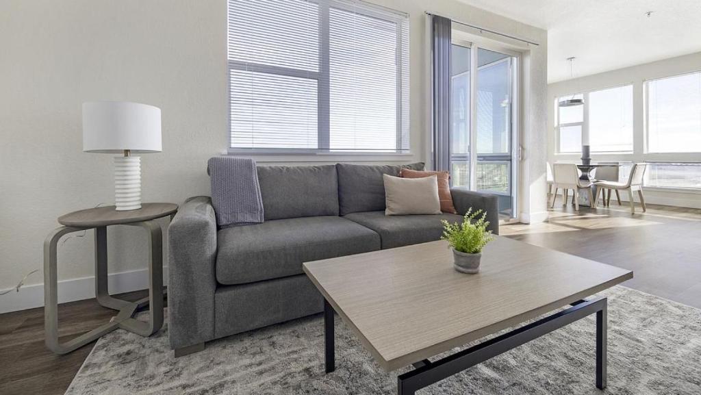een woonkamer met een bank en een tafel bij Landing Modern Apartment with Amazing Amenities (ID9253X93) in Denver