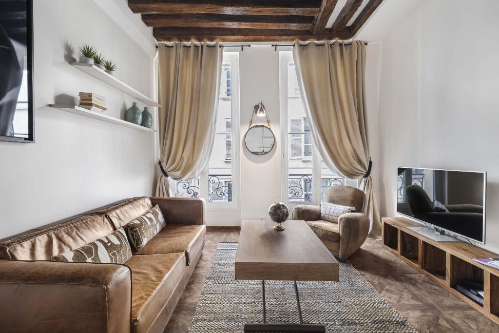 a living room with a couch and a table at Gentilhomme in Paris