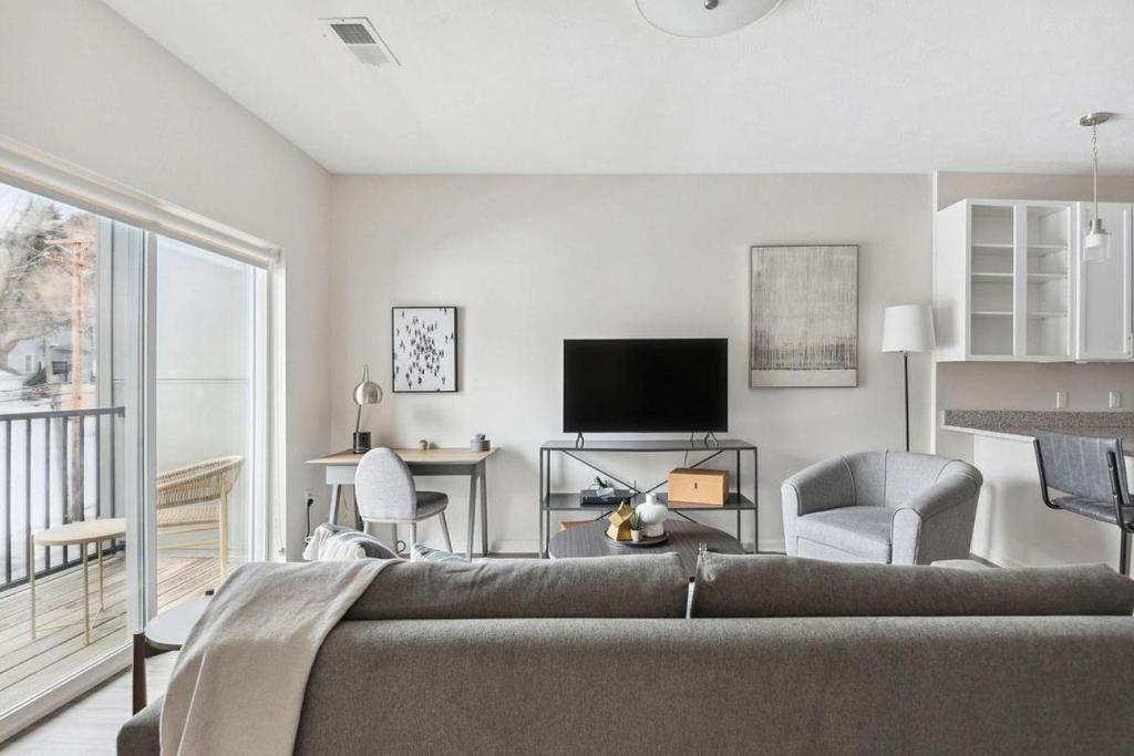 ein Wohnzimmer mit einem Sofa und einem TV in der Unterkunft Landing Modern Apartment with Amazing Amenities (ID7435X07) in Omaha