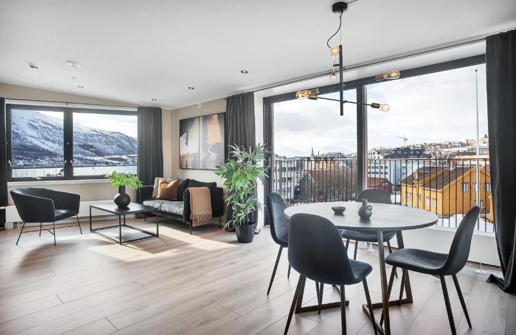 uma sala de estar com mesa e cadeiras em TA Vervet Apartment Hotel em Tromsø