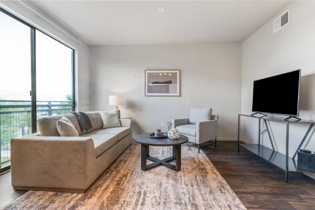 un soggiorno con divano, TV e tavolo di Landing Modern Apartment with Amazing Amenities (ID2956X24) ad Austin
