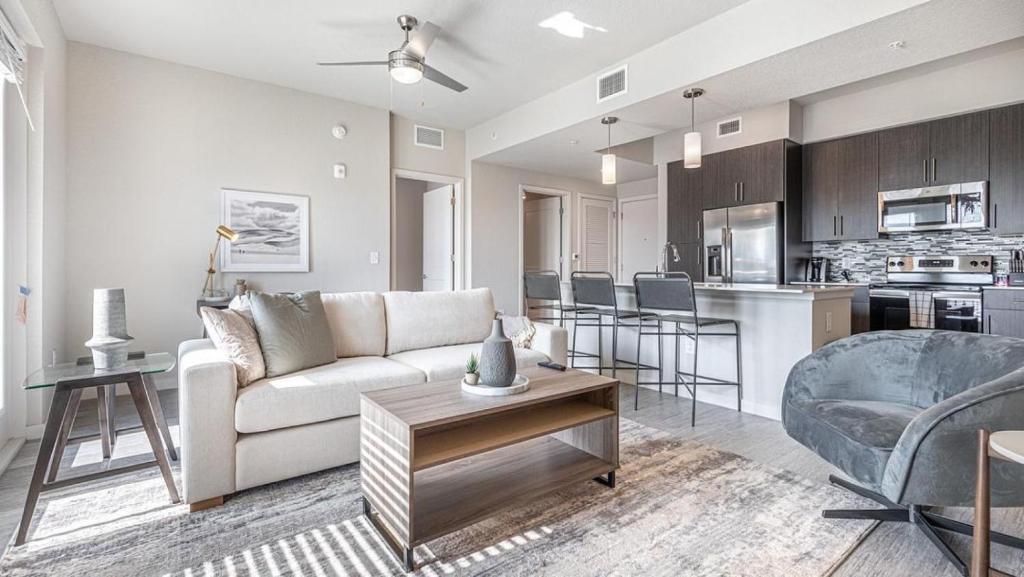 uma sala de estar com um sofá branco e uma cozinha em Landing Modern Apartment with Amazing Amenities (ID8083X57) em Fort Myers Villas