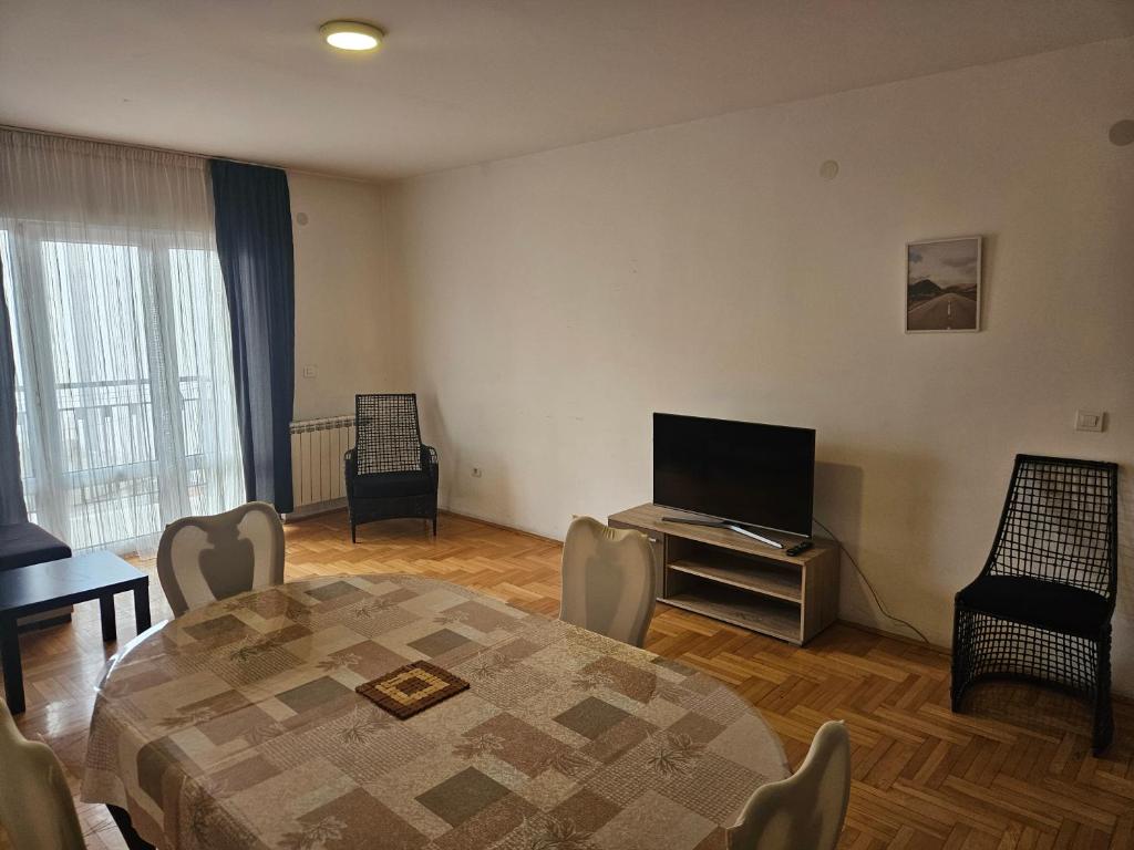 ein Wohnzimmer mit einem Tisch und einem Flachbild-TV in der Unterkunft apartament 33 in Belgrad