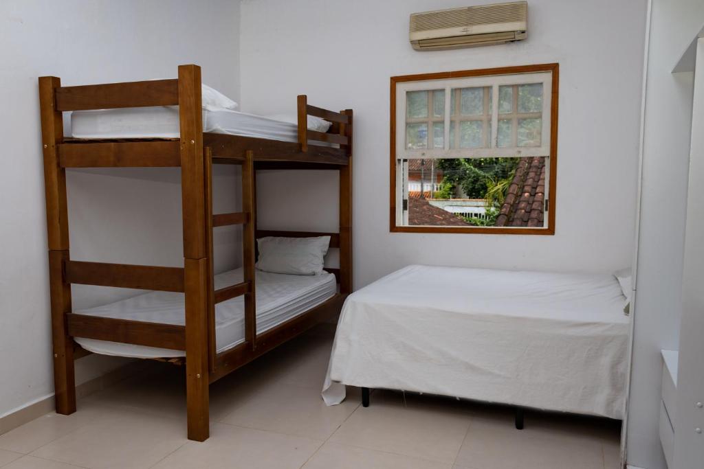 1 dormitorio con 2 literas y ventana en Aluguel Temporada praia Maresias, en São Sebastião