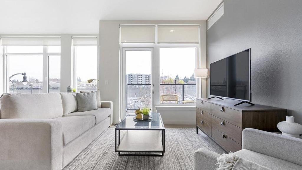 uma sala de estar com um sofá e uma televisão de ecrã plano em Landing Modern Apartment with Amazing Amenities (ID8566X33) em Vancouver