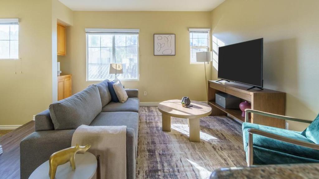 een woonkamer met een bank en een tv bij Landing Modern Apartment with Amazing Amenities (ID7986X55) in Rancho Cucamonga