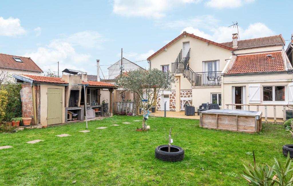 una casa con un patio con un neumático en el césped en Beautiful Home In Juvisy-sur-orge With Kitchen, en Juvisy-sur-Orge