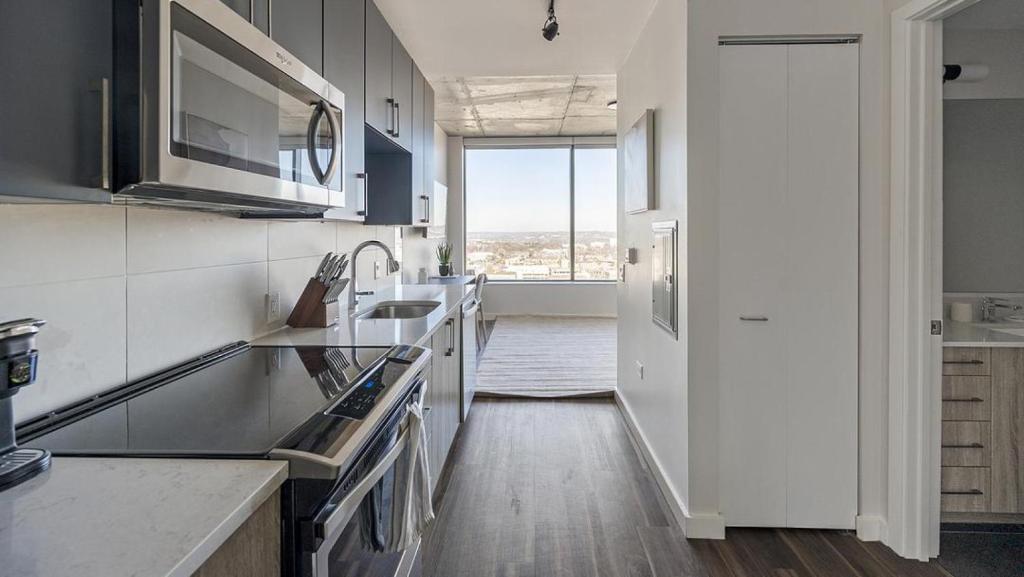 Landing Modern Apartment with Amazing Amenities (ID1398X857) في ناشفيل: مطبخ به أجهزة بيضاء ونافذة كبيرة
