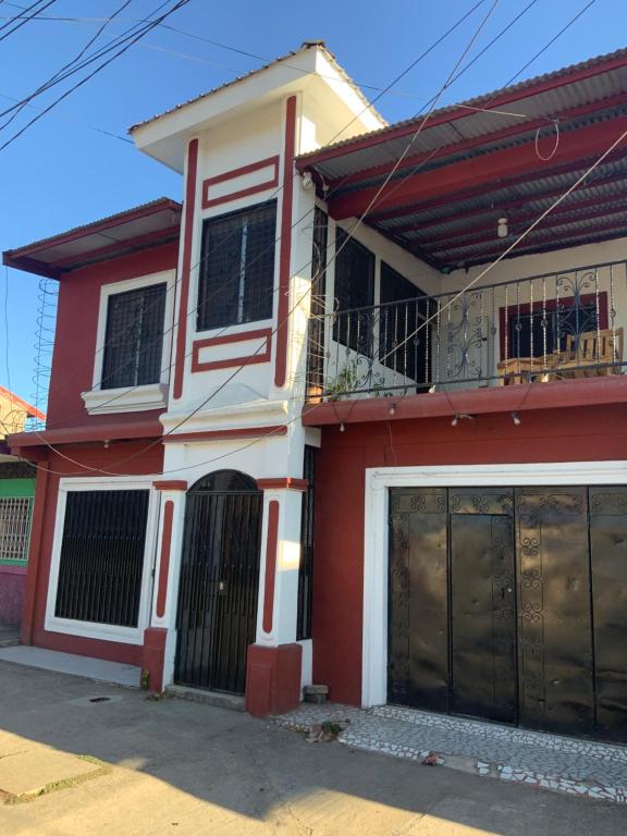 a red and white house with a garage at LA DOLCE VITA FRANCOPHONE in Estelí