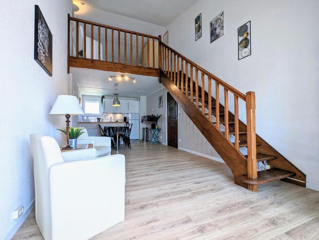 - un salon avec un escalier en bois dans une maison dans l'établissement Appartement T4/parking privé/wifi/50m de la plage, au Cap d'Agde