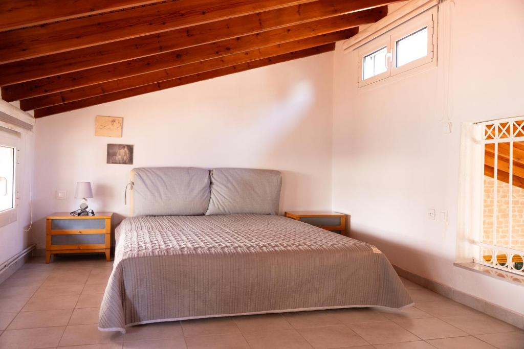 a bedroom with a bed and two windows at Casa di Porto in Neos Marmaras