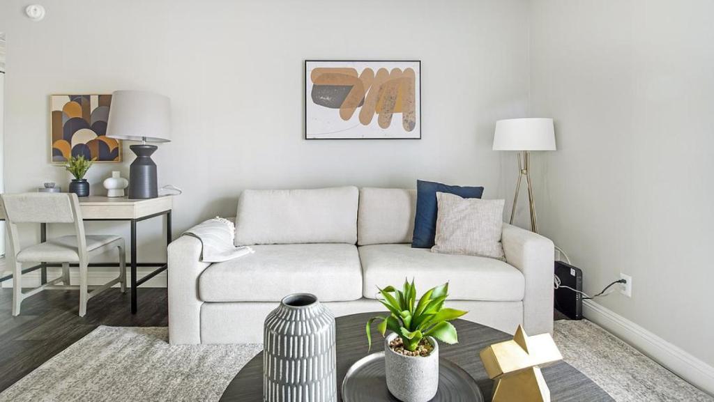 uma sala de estar com um sofá branco e uma mesa em Landing Modern Apartment with Amazing Amenities (ID1232X656) em Las Vegas