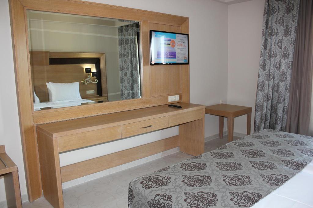 a bedroom with a large mirror and a bed at Grand Meteora Hotel in Kalabaka