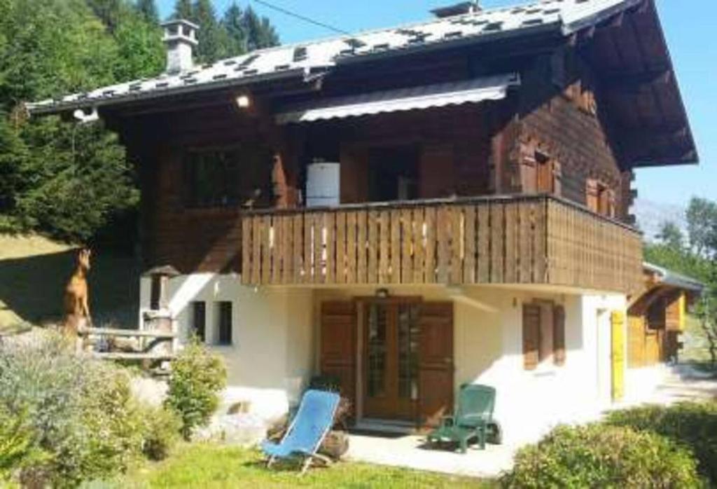 a house with a deck and two chairs in front of it at Chalet de 7 chambres avec terrasse et wifi a Saint Gervais les Bains in Saint-Gervais-les-Bains