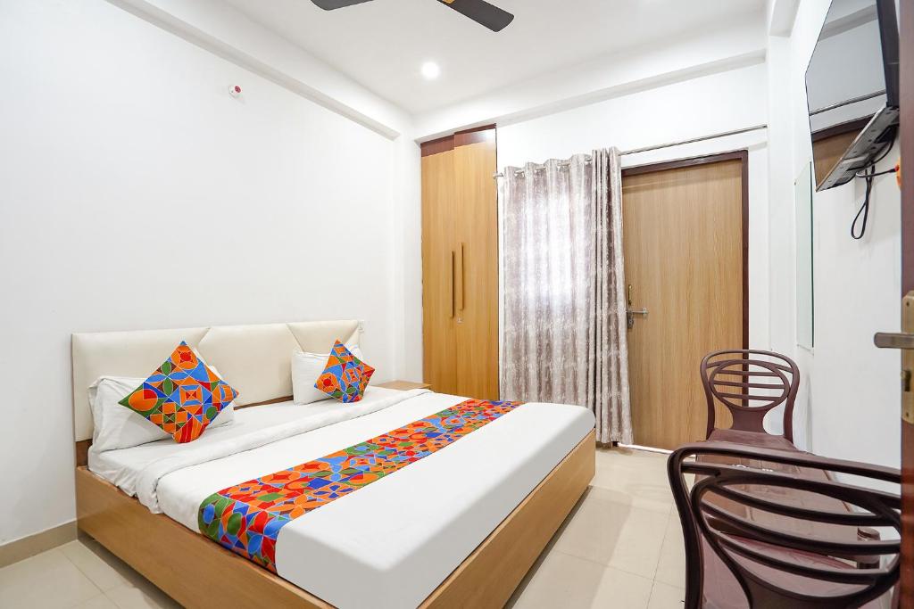 - une chambre avec un lit et une chaise dans l'établissement FabHotel SK Residency, à Varanasi