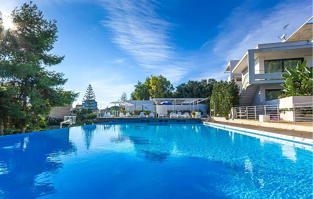 ein großer blauer Swimmingpool vor einem Haus in der Unterkunft 2 Bedroom Cozy Home In Marina Di Ragusa in Marina di Ragusa