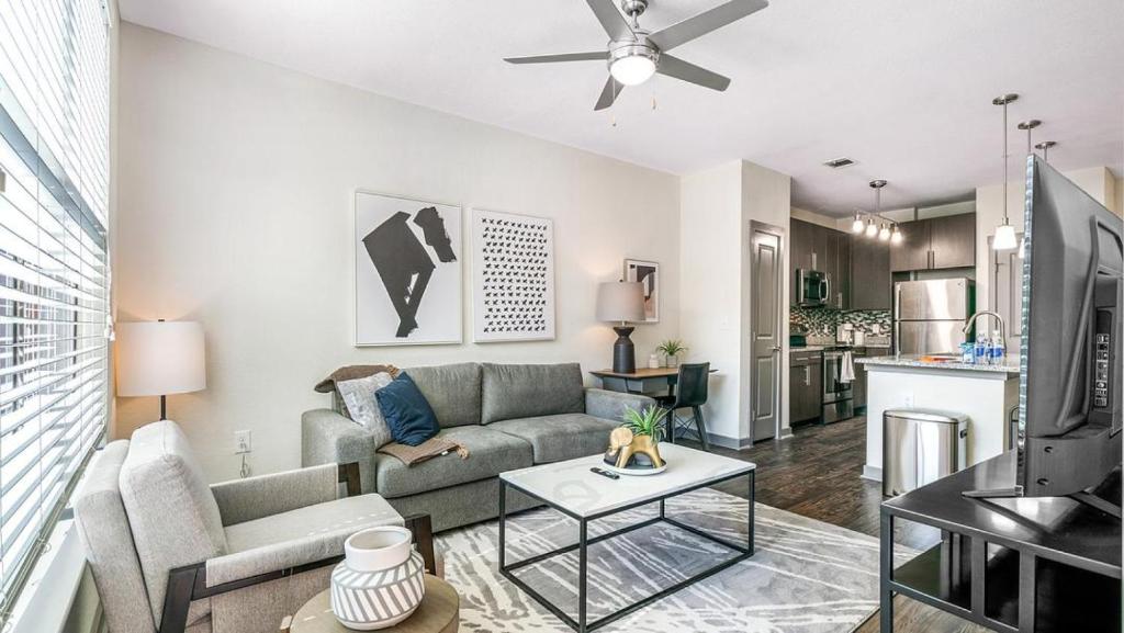 uma sala de estar com um sofá e uma mesa em Landing Modern Apartment with Amazing Amenities (ID1172X300) em San Antonio