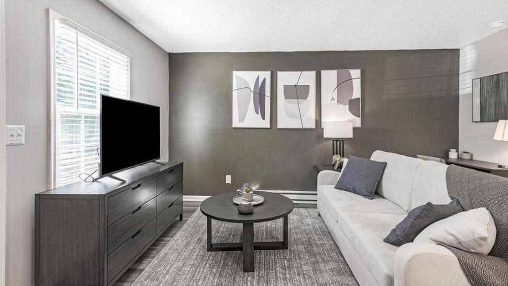 - un salon avec un canapé blanc et une télévision dans l'établissement Landing Modern Apartment with Amazing Amenities (ID1170X559), à Greensboro