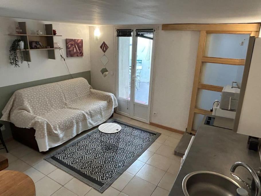uma sala de estar com uma cama e um tapete em Studio Sanae em Lézignan-Corbières