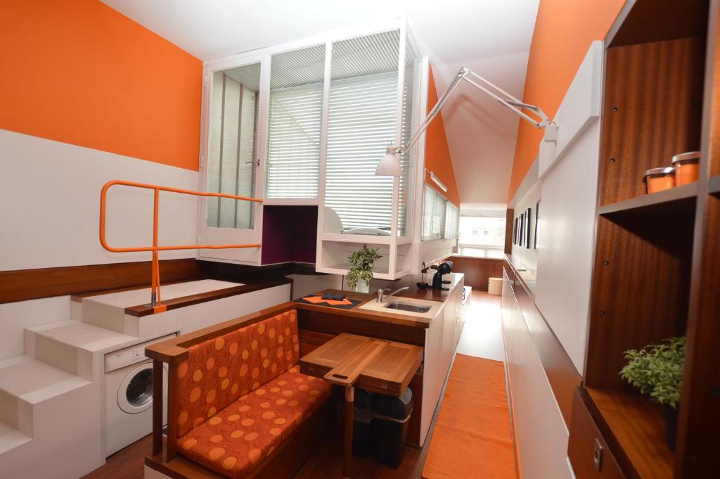 eine orangefarbene und weiße Küche mit einer Bank und einem Waschbecken in der Unterkunft The Serra Vision in Ivrea