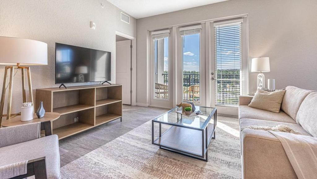 a living room with a couch and a tv at Landing Modern Apartment with Amazing Amenities (ID8094X36) in Fort Myers Villas