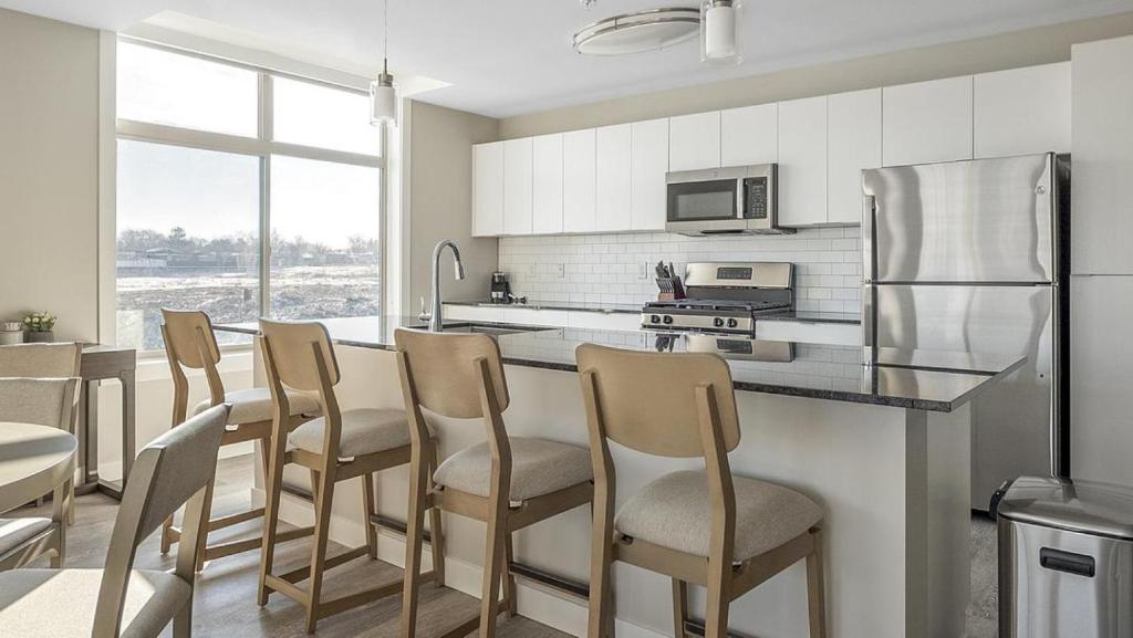 a kitchen with a group of chairs at a counter at Landing Modern Apartment with Amazing Amenities (ID1348X886) in Sandy