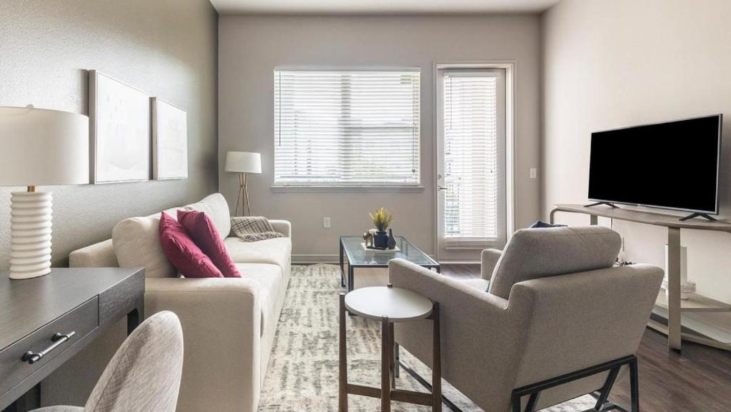 uma sala de estar com um sofá e uma televisão em Landing Modern Apartment with Amazing Amenities (ID9245X93) em Irving